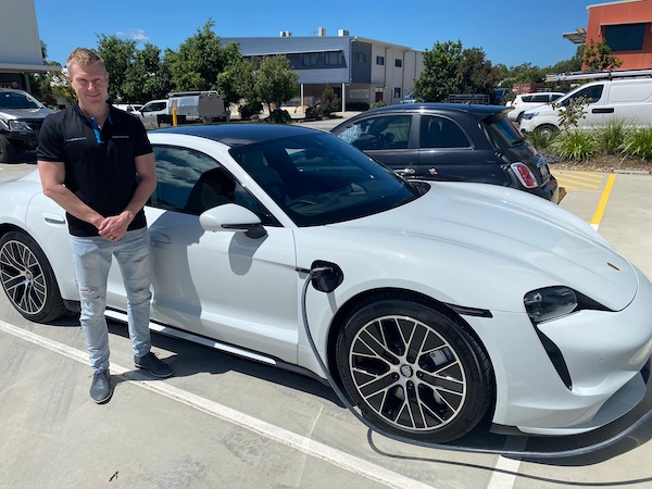 REA Global Director Michael Mrowka with an electric Porsche